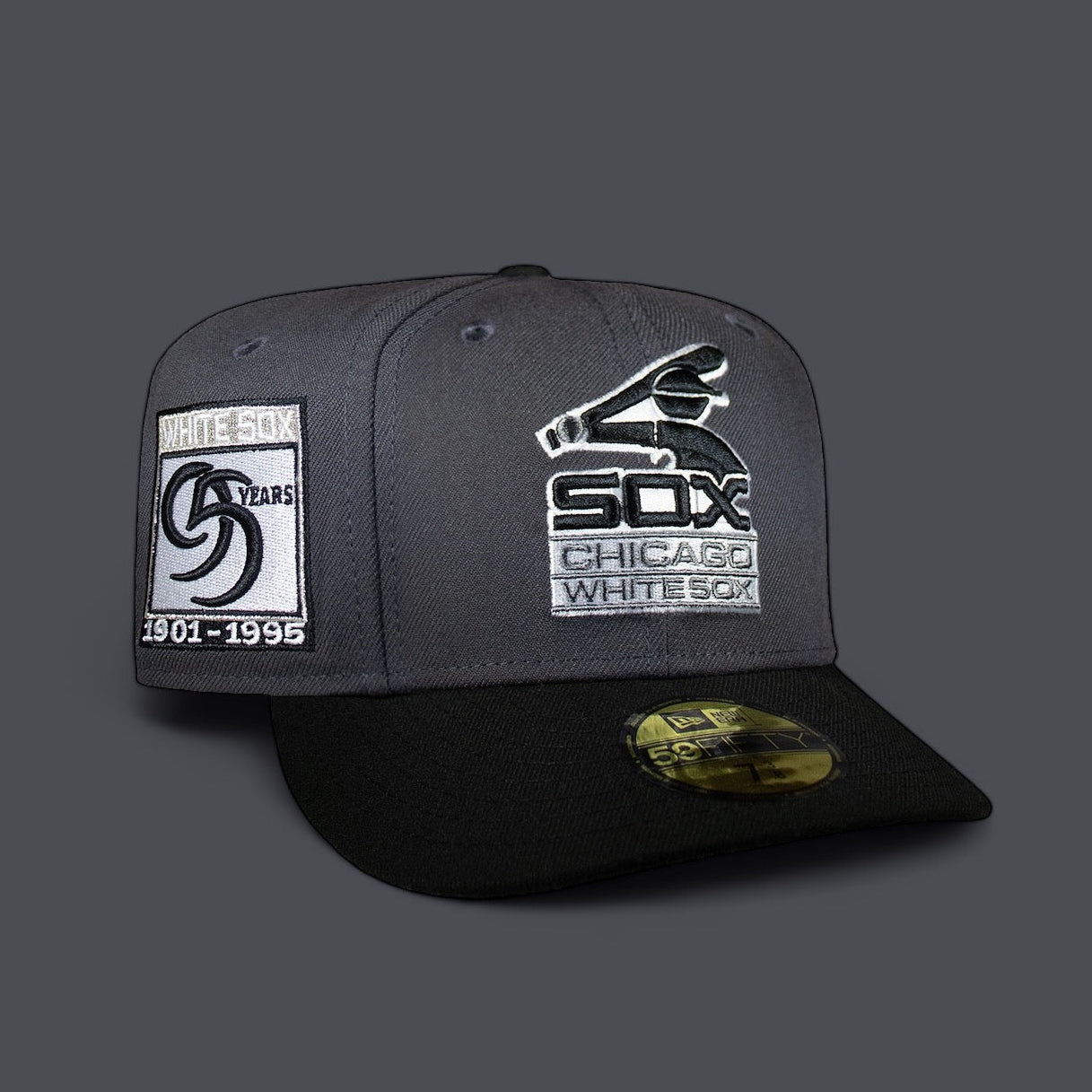 A fitted cap with the Chicago White Sox logo in dark grey and black colors, celebrating 95 years of the MLB team.